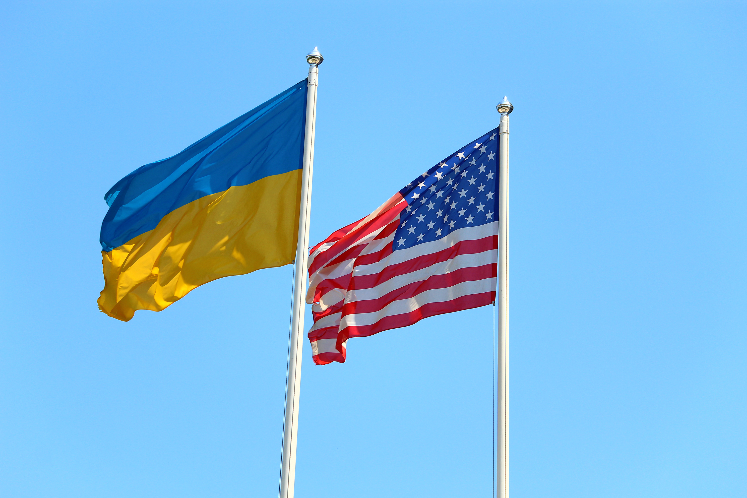 Ukrainian and American flags waving together, professional photograph